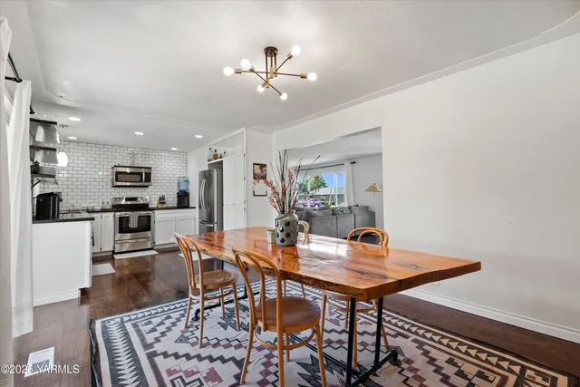 a workspace with wooden floor and a chandelier