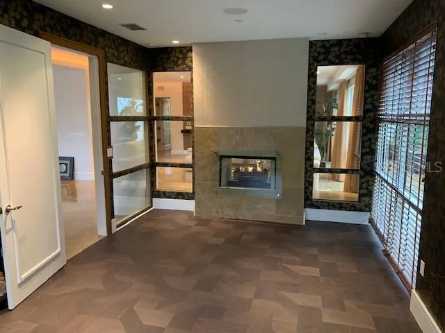 a view of a refrigerator in kitchen and an empty room