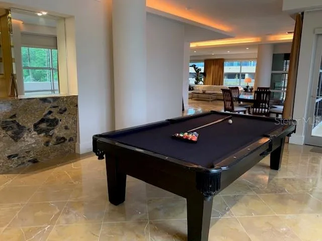 a room with pool table and windows