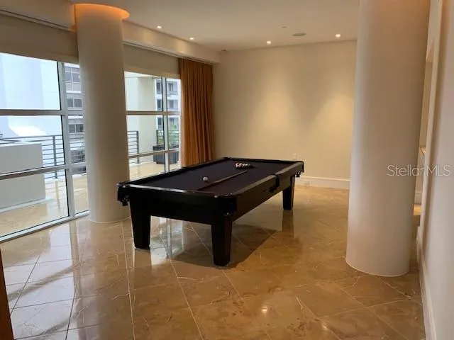 a room with pool table and windows