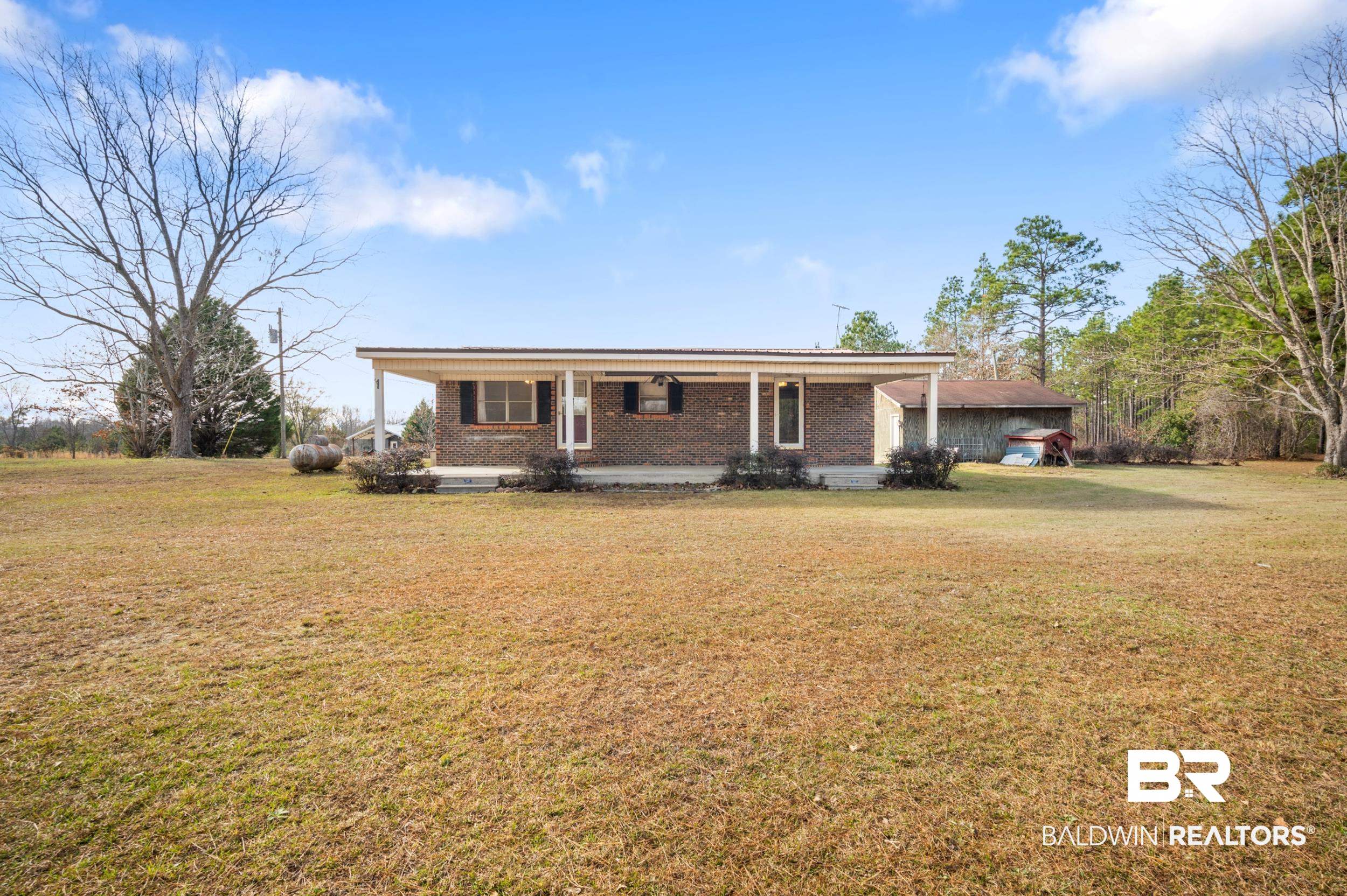Single story home with a porch, a front yard, and brick siding