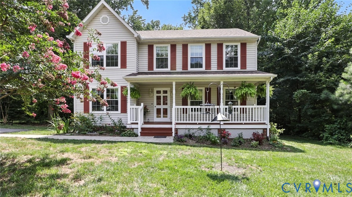 Colonial house featuring a front yard, a porch, an