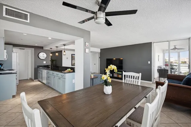 a kitchen with a dining table chairs and refrigerator