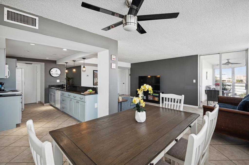 100 Golden Isles Drive, Unit 508 Hallandale Beach, FL 33009 - Photo 6 of 17 a kitchen with a dining table chairs and refrigerator