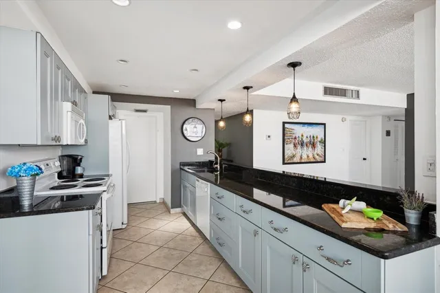 a kitchen with granite countertop a sink and a stove top oven