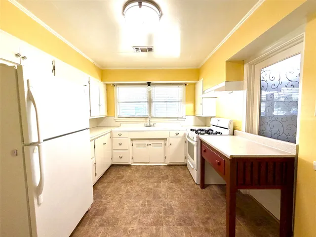 a kitchen with a refrigerator a sink and a large window
