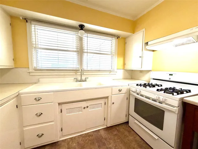 a kitchen with white cabinets and a stove top oven
