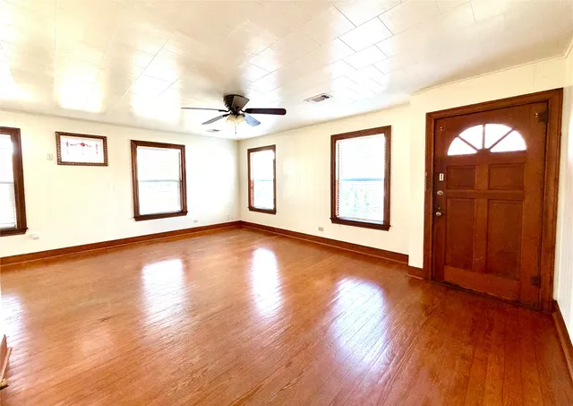 a view of an empty room with window and wooden floor