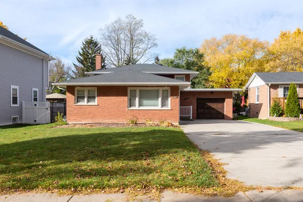 a front view of a house with a garden and yard