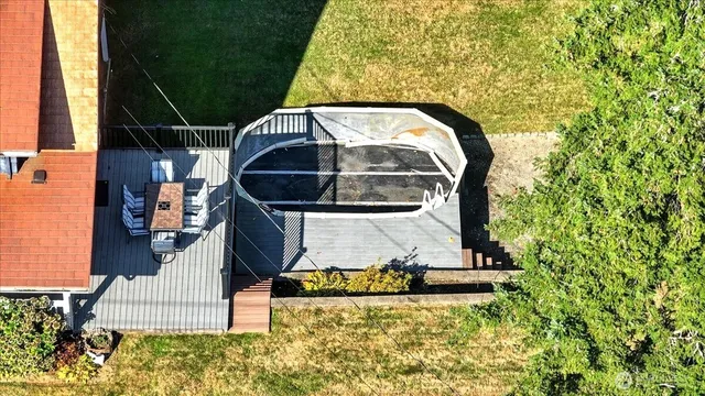an aerial view of a house with swimming pool and large trees