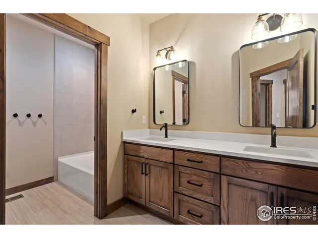 a bathroom with a double vanity sink and a mirror