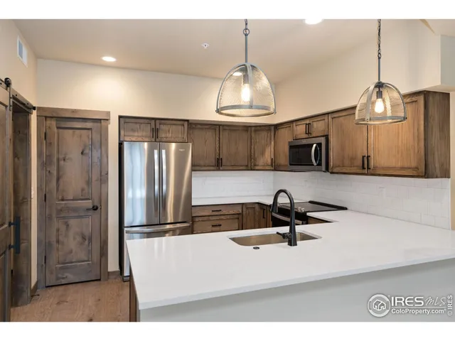 a kitchen with kitchen island stainless steel appliances a sink refrigerator and microwave