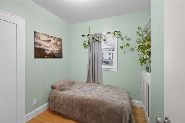 a bedroom with a bed and a painting on the wall
