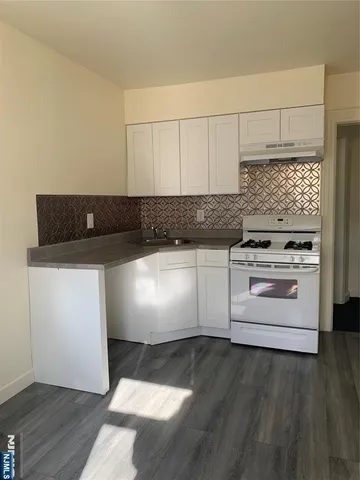 a kitchen with granite countertop white cabinets and white appliances