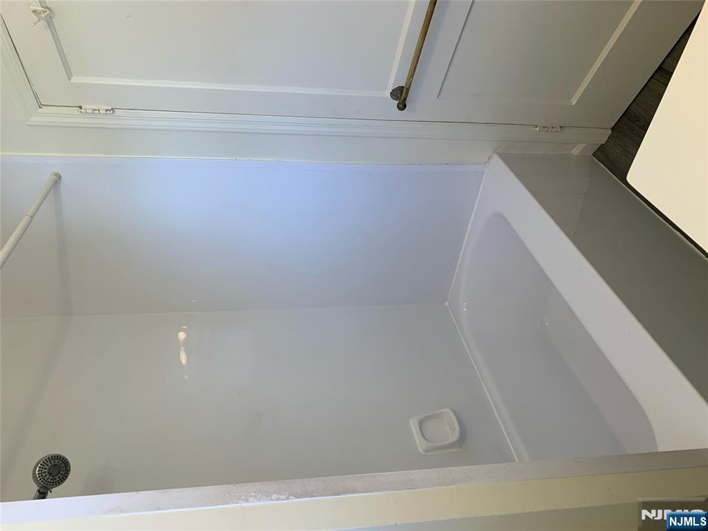 505 Schuyler Avenue, Unit 1 North Arlington, NJ 07031 - Photo 4 of 5 a bathroom with a granite countertop bathtub shower and toilet