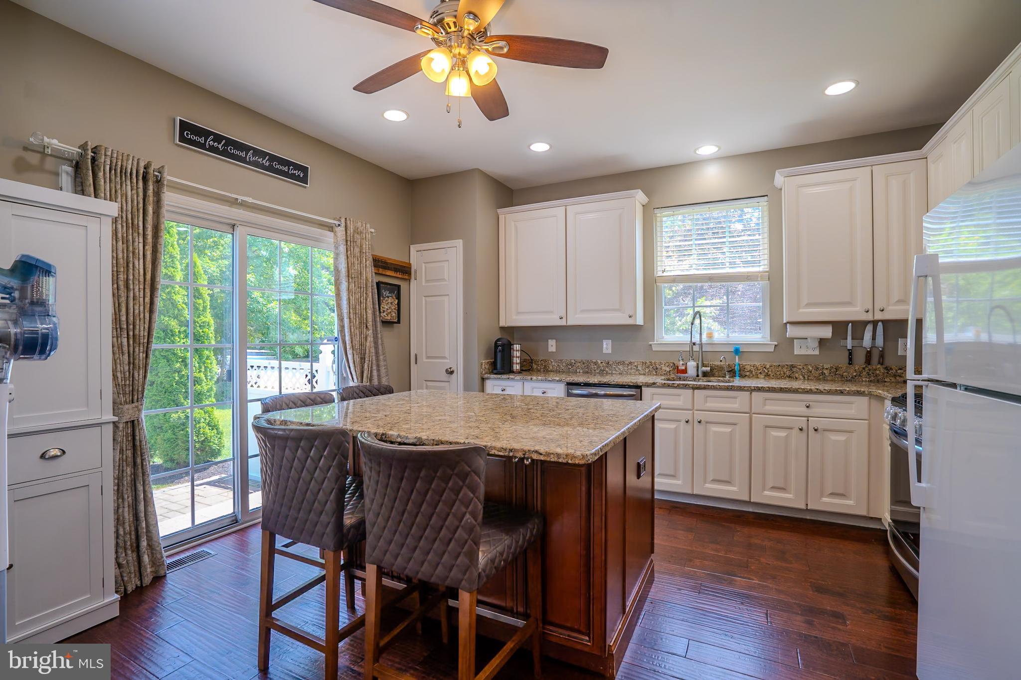 101 Beacon Drive Deptford, NJ 08096 - Photo 18 of 40 a kitchen with stainless steel appliances granite countertop a stove a refrigerator a sink dishwasher a dining table and chairs with wooden floor