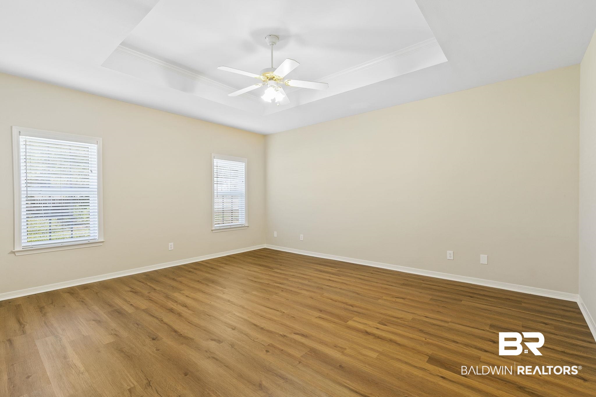 9631 Bay Meadows Avenue Fairhope, AL 36532 - Photo 17 of 49 Unfurnished room with hardwood / wood-style floors, a tray ceiling, and a healthy amount of sunlight