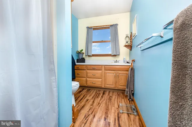 a view of kitchen with stainless steel appliances kitchen island granite countertop cabinets and a window