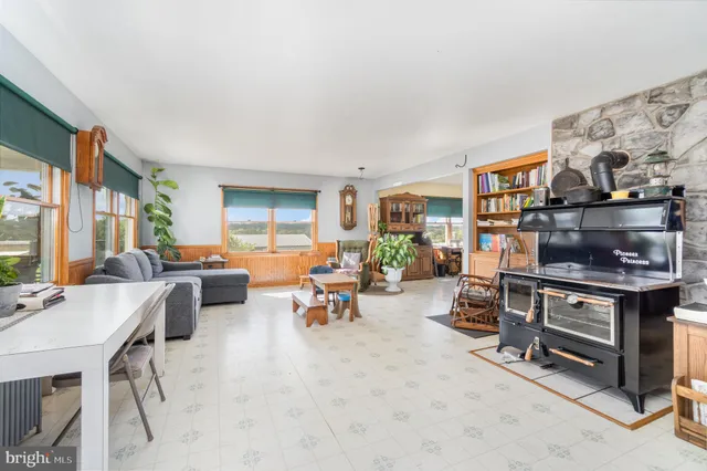 a living room with fireplace furniture and large windows