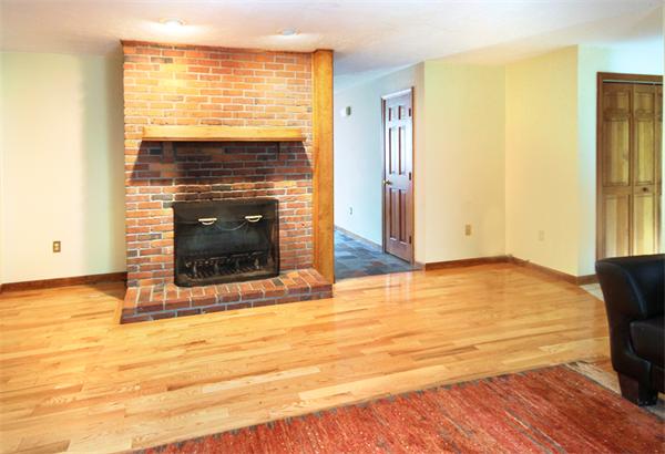 64 Cedar Street Walpole, MA 02081 - Photo 5 of 28 a view of an empty room with wooden floor and a fireplace