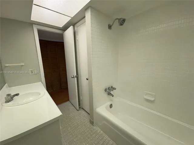 a bathroom with a tub a sink and a shower