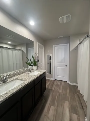 a bathroom with a granite countertop sink and a mirror