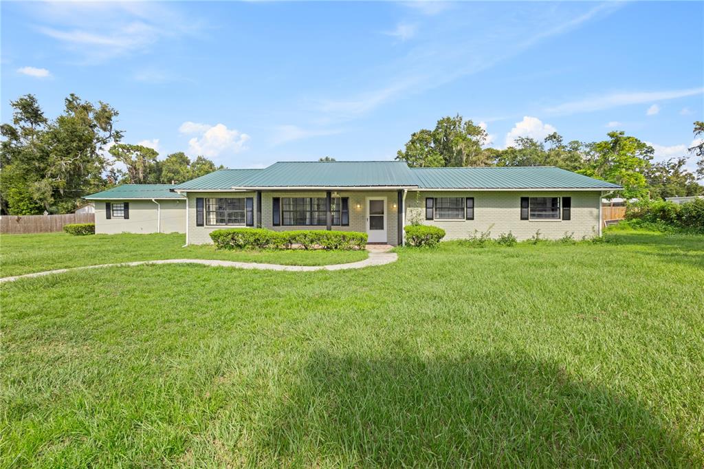 1110 West Dees Road Lakeland, FL 33809 - Photo 1 of 1 a front view of a house with a garden and trees