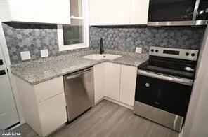 a kitchen with a sink stove and cabinets