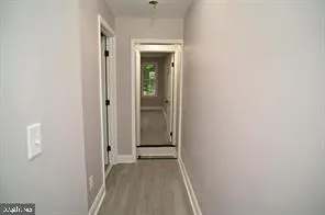 a view of a hallway with wooden floor