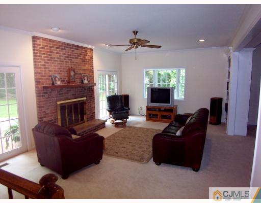 3 Fox Hill Road Edison, NJ 08820 - Photo 5 of 10 a living room with furniture a flat screen tv and a fireplace