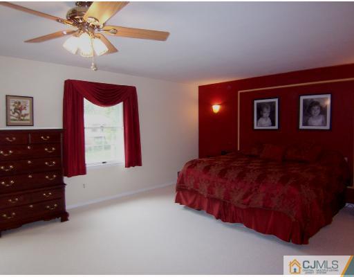 3 Fox Hill Road Edison, NJ 08820 - Photo 8 of 10 a spacious bedroom with a bed a chandelier and a dresser