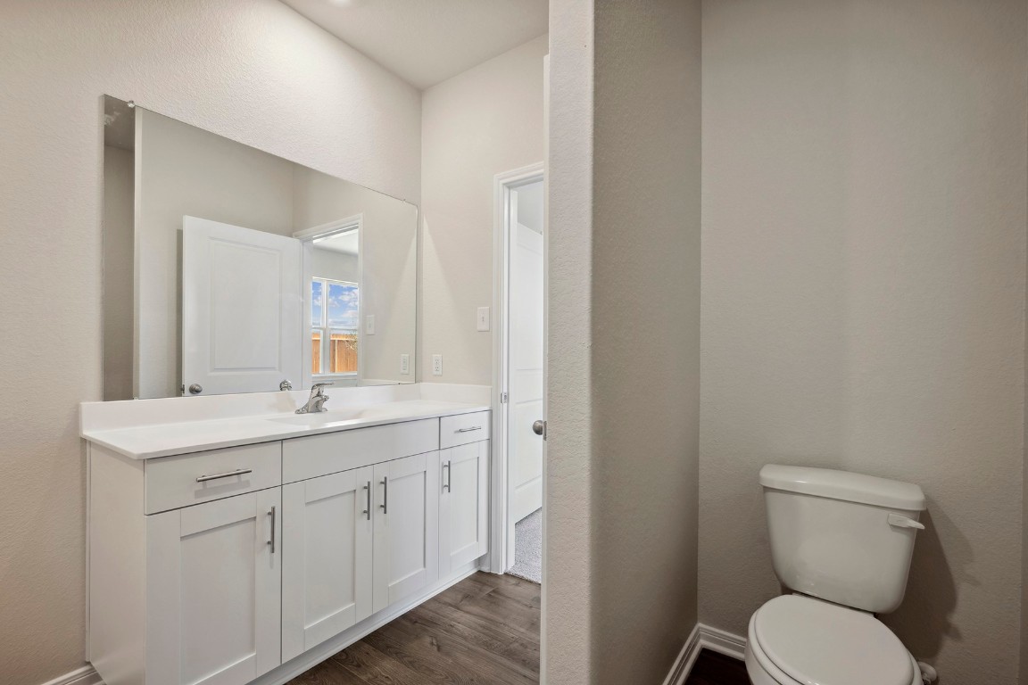 10403 Red Cardinal Drive Cleveland, TX 77328 - Photo 14 of 24 a bathroom with a toilet a sink and mirror