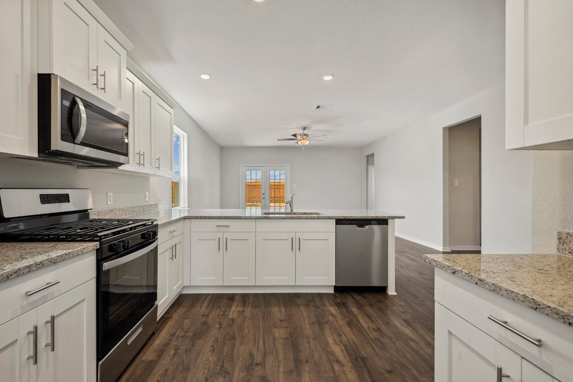 10403 Red Cardinal Drive Cleveland, TX 77328 - Photo 5 of 24 a kitchen with granite countertop cabinets stainless steel appliances and a sink