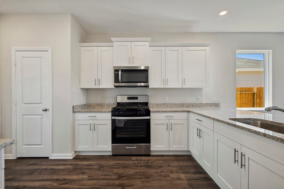 10403 Red Cardinal Drive Cleveland, TX 77328 - Photo 6 of 24 a kitchen with stainless steel appliances granite countertop a stove and a sink