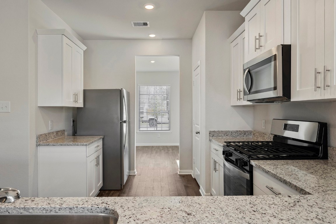 10403 Red Cardinal Drive Cleveland, TX 77328 - Photo 7 of 24 a kitchen with stainless steel appliances granite countertop a refrigerator stove top oven and sink