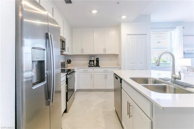 a kitchen that has a sink cabinets counter space and appliances
