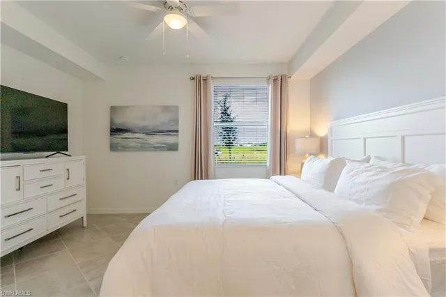 a bedroom with a bed tv and window