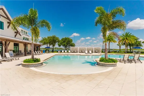 a view of a house with swimming pool and sitting area