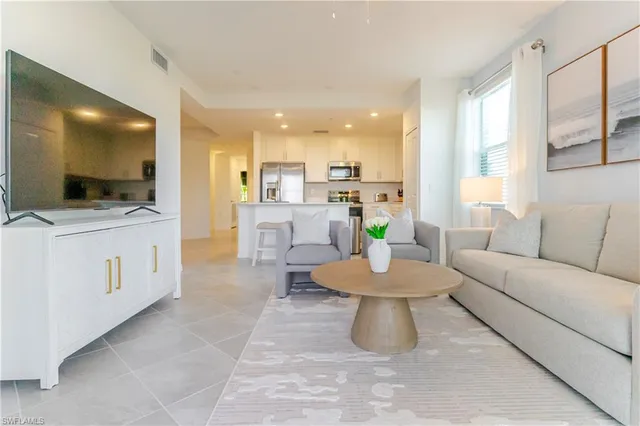 a living room with kitchen island furniture and a flat screen tv