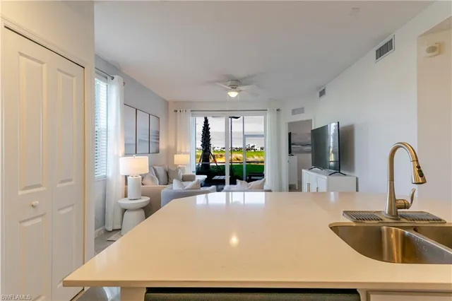 a large white kitchen with a sink and a refrigerator