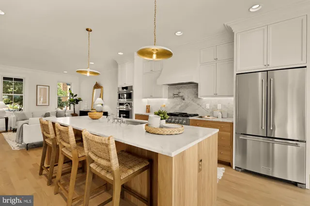 a kitchen with stainless steel appliances granite countertop a sink a stove and a wooden floors