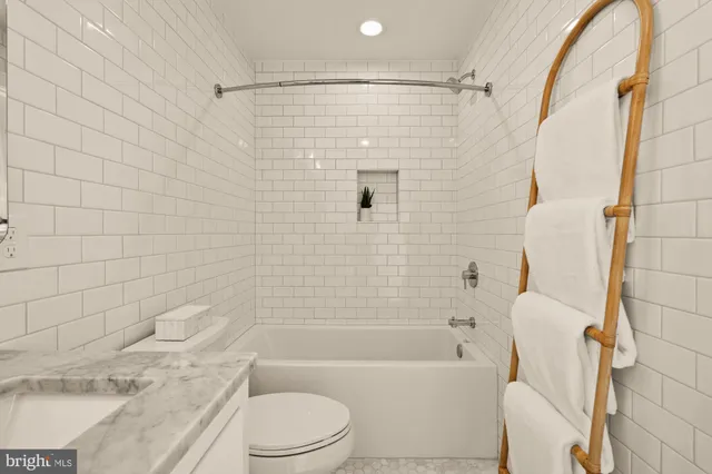 a living room with furniture kitchen view and a wooden floor