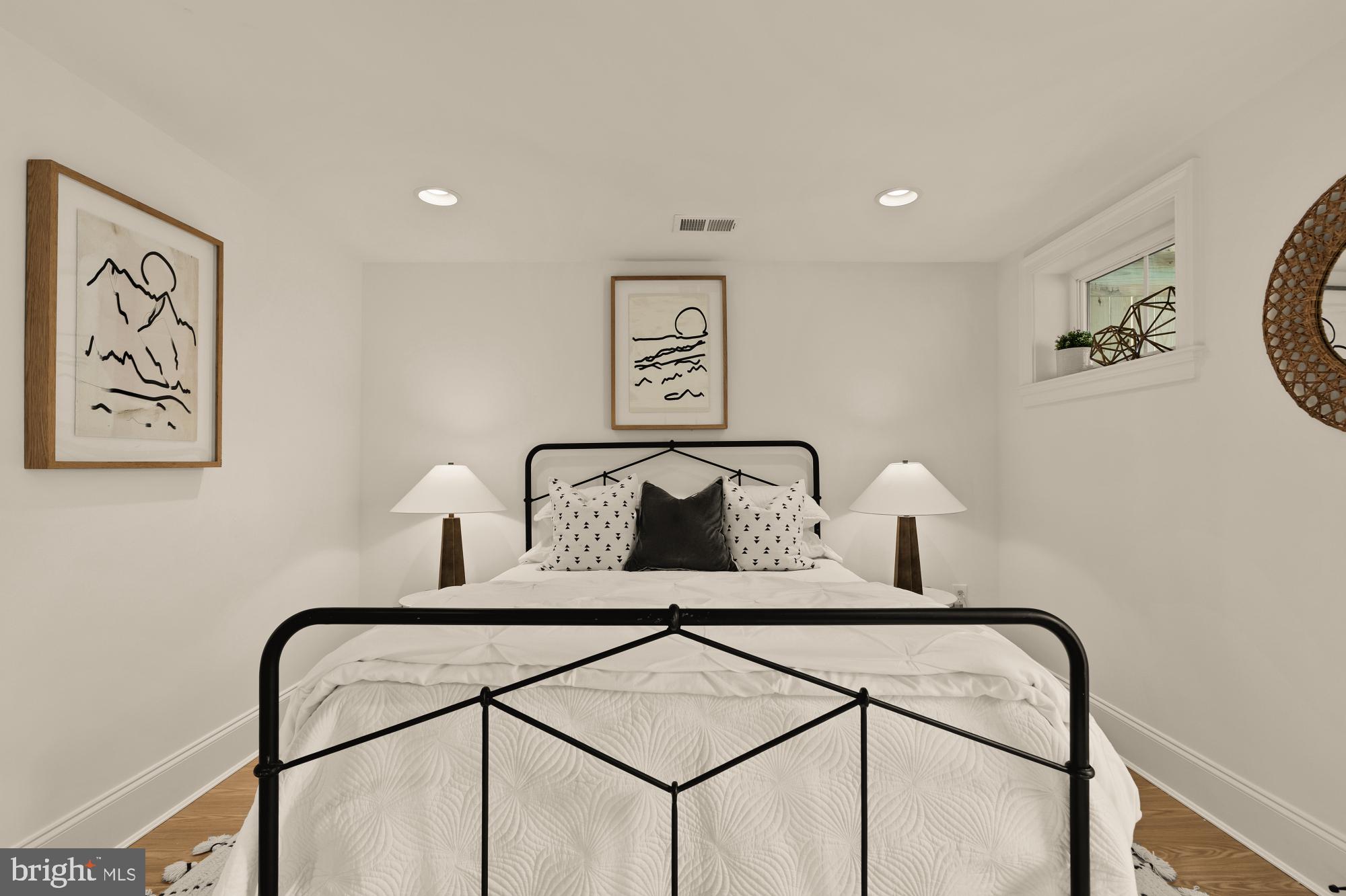 4830 8th Street Northwest Washington, DC 20011 - Photo 49 of 54 a bedroom with a bed a lamp on the wall and a window