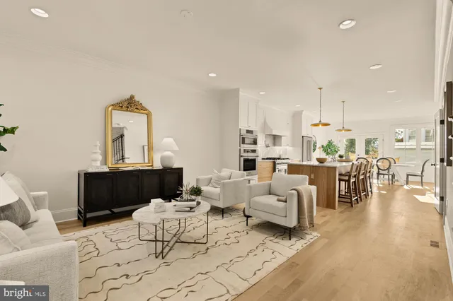 a kitchen with stainless steel appliances granite countertop a stove a kitchen island a dining table and chairs