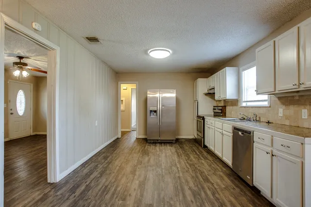 a view of a kitchen with wooden floor and electronic appliances