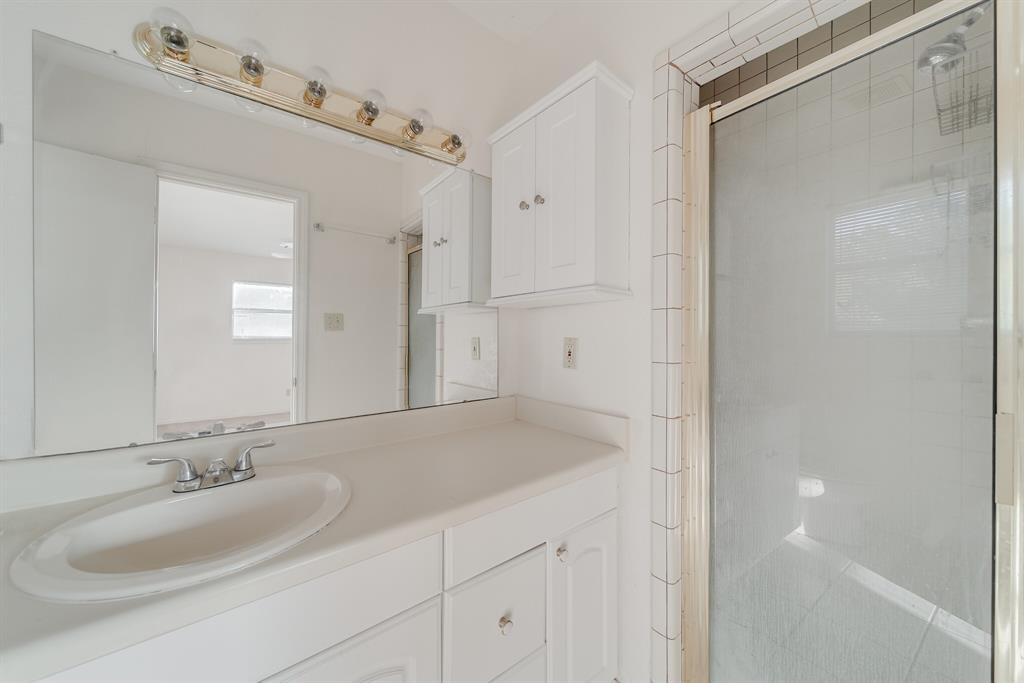 1963 East Dove Road Southlake, TX 76092 - Photo 19 of 27 a bathroom with a granite countertop sink a mirror and shower