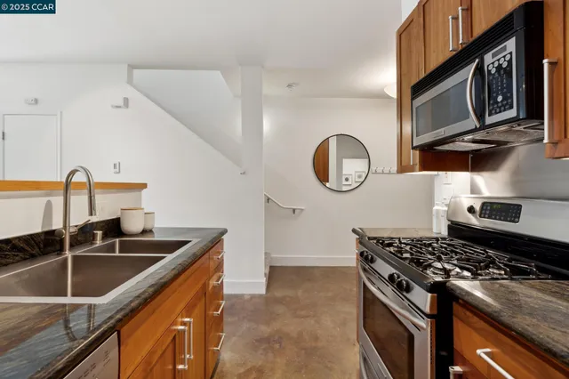 a kitchen with stainless steel appliances granite countertop a sink stove and cabinets