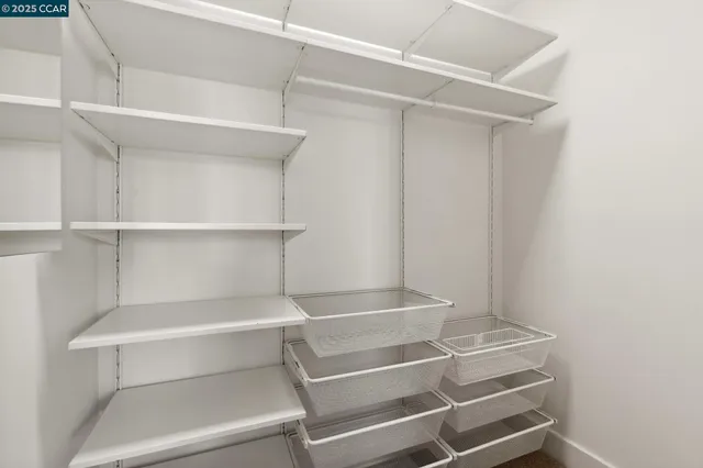 a view of walk in closet with empty racks