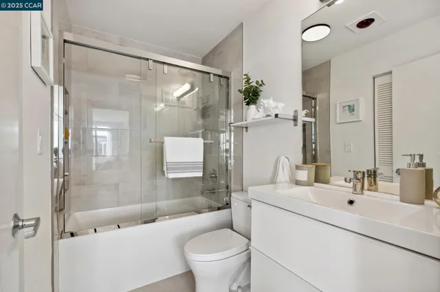 a bathroom with a bathtub shower sink mirror and toilet