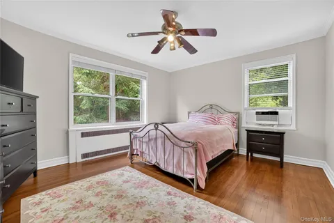 a bedroom with a bed and a dresser next to a window